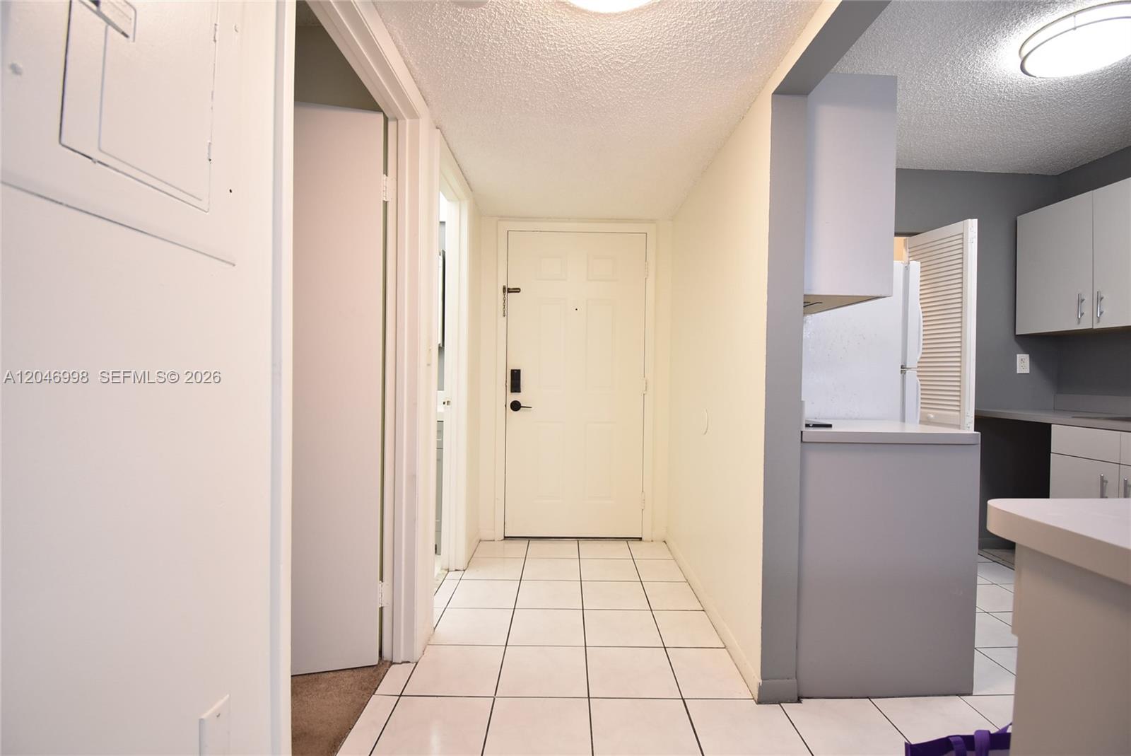 A tiled entryway leads to a white front door with a kitchen visible on the right — 20741 NE 4th Ct # 104, Miami FL 33179, MIAMI, FL