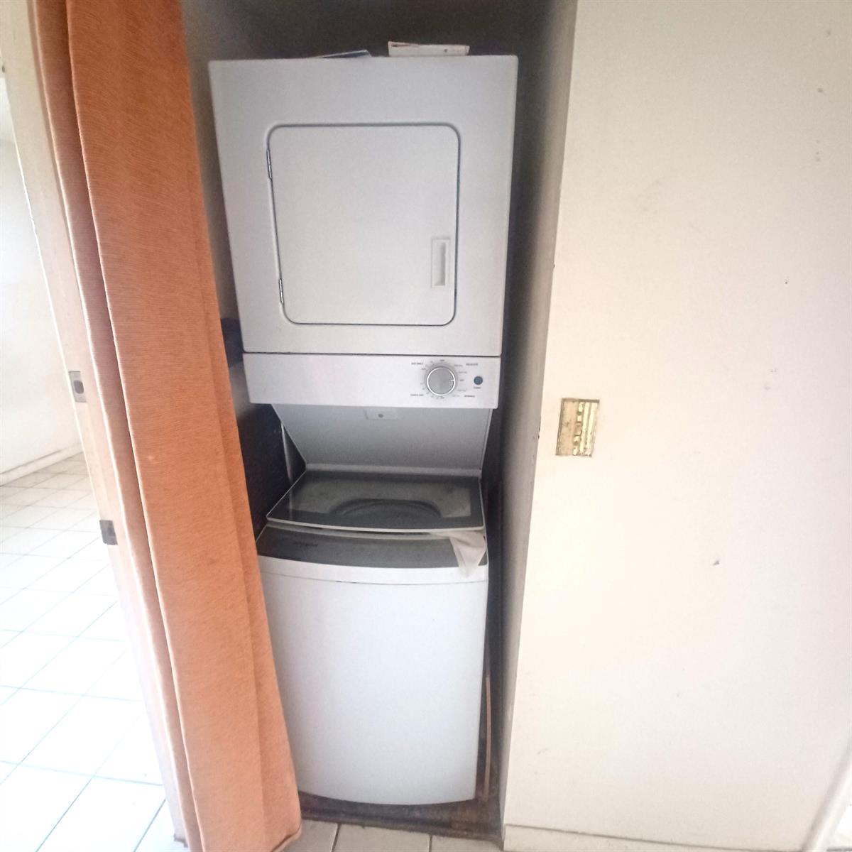 A stacked washer and dryer unit is installed in a small closet — 3186 Via Poinciana # 311, FL 33467, FL