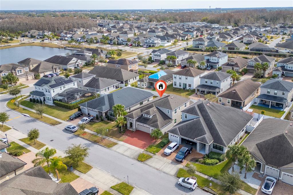 An aerial view shows a suburban neighborhood with houses, a lake, and a marked property — 3040 CARDILLINO WAY, KISSIMMEE, FL
