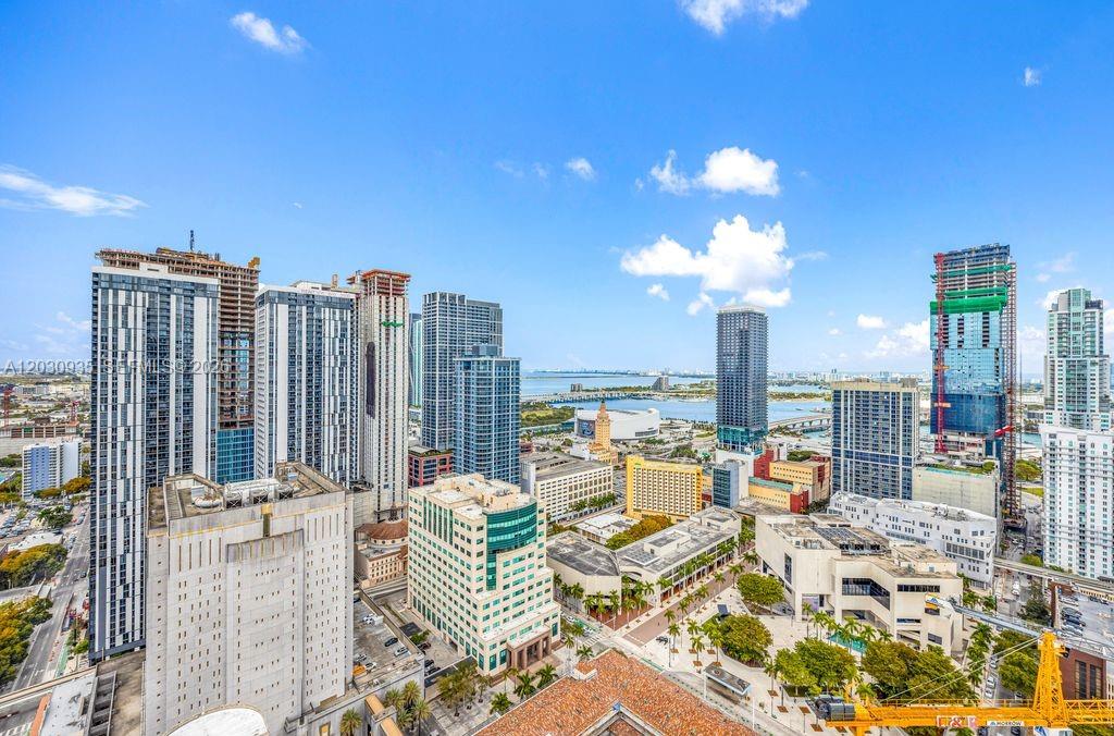 An aerial view of a dense city skyline featuring numerous high-rise buildings under a blue sky — 225 N Miami Ave # 3507, Miami FL 33128, MIAMI, FL