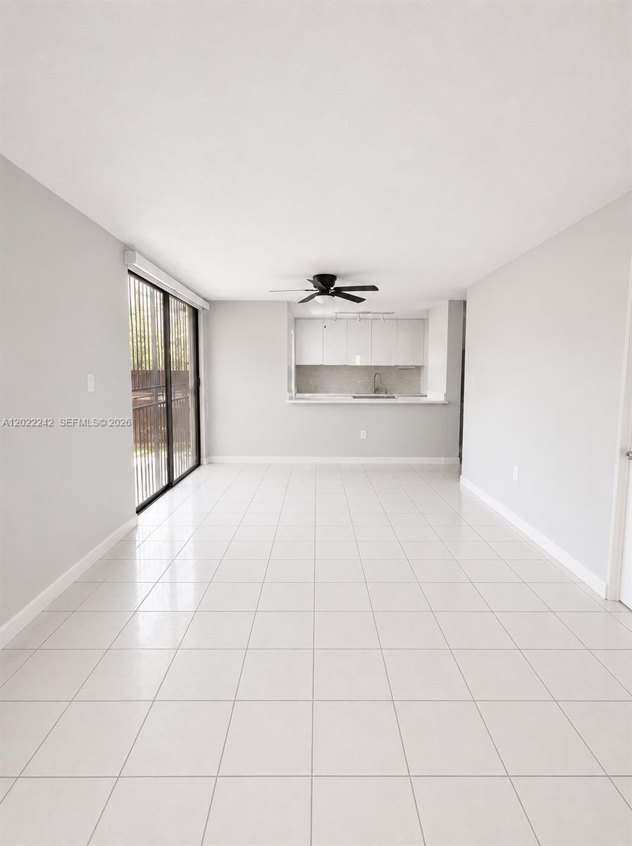 A bright, open-concept living area features white tile flooring, a ceiling fan, and a kitchen — 20033 SW 123rd Dr, Miami FL 33177, MIAMI, FL