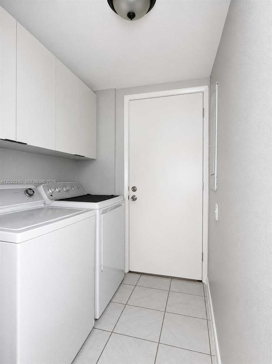 A laundry room features white appliances, overhead cabinets, and light-colored tile flooring — 20033 SW 123rd Dr, Miami FL 33177, MIAMI, FL