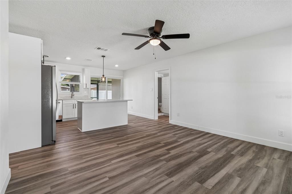 A kitchen with a white island and stainless steel appliances opens into a living area — 4417 W FAIRVIEW HEIGHTS, TAMPA, FL