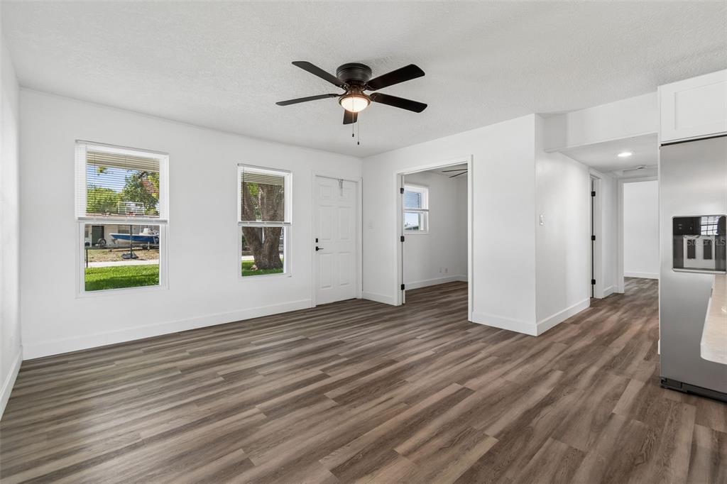 A bright room features wood-look flooring, white walls, a ceiling fan, and two windows — 4417 W FAIRVIEW HEIGHTS, TAMPA, FL