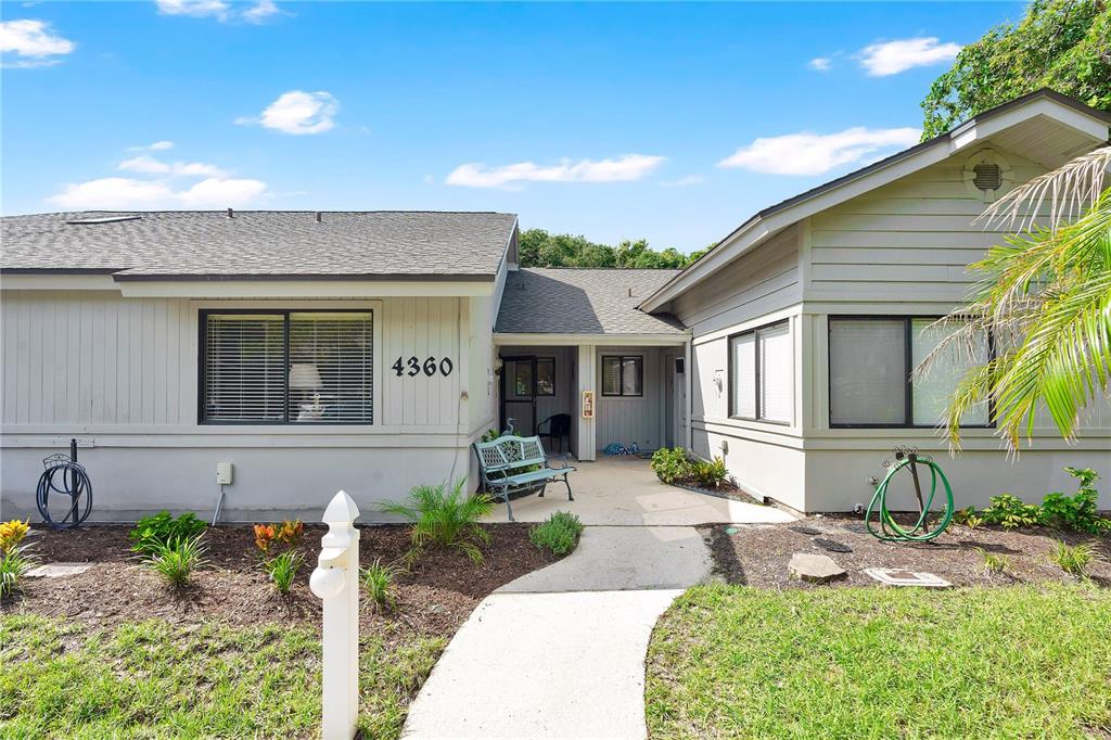 A single-story house with light gray siding, a concrete walkway, and a small front bench — 4360 SEA MIST DRIVE, NEW SMYRNA BEACH, FL