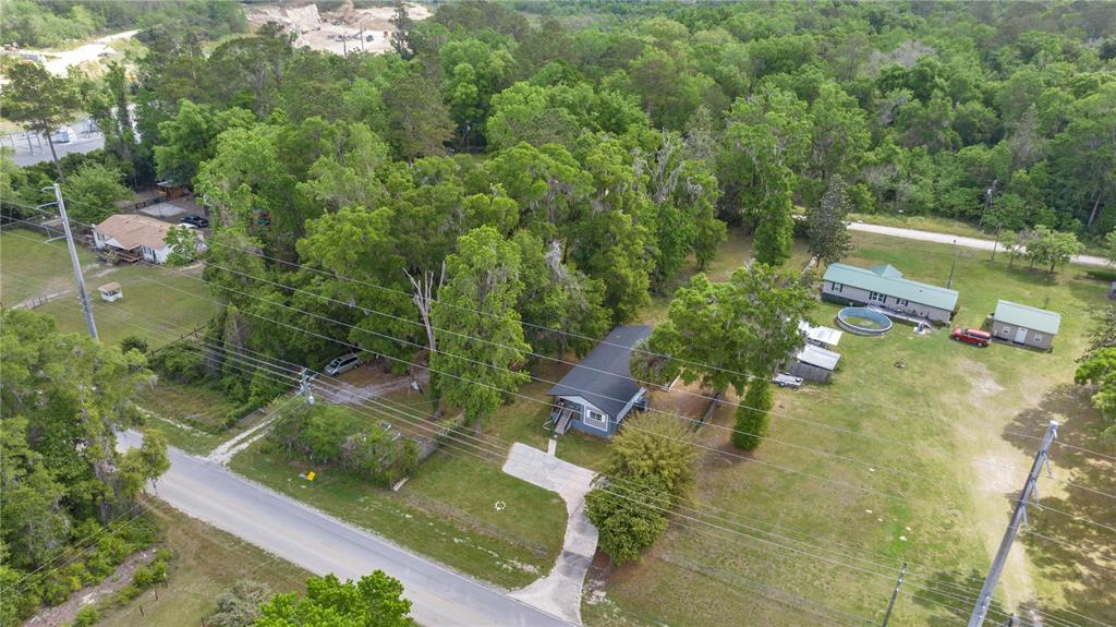 An aerial view shows a house with a driveway and a large, tree-filled yard — 1127 SW 140TH AVENUE, OCALA, FL