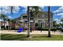 A multi-story residential building stands behind a playground with a blue slide — 3367 S KIRKMAN ROAD UNIT 1111, ORLANDO, FL