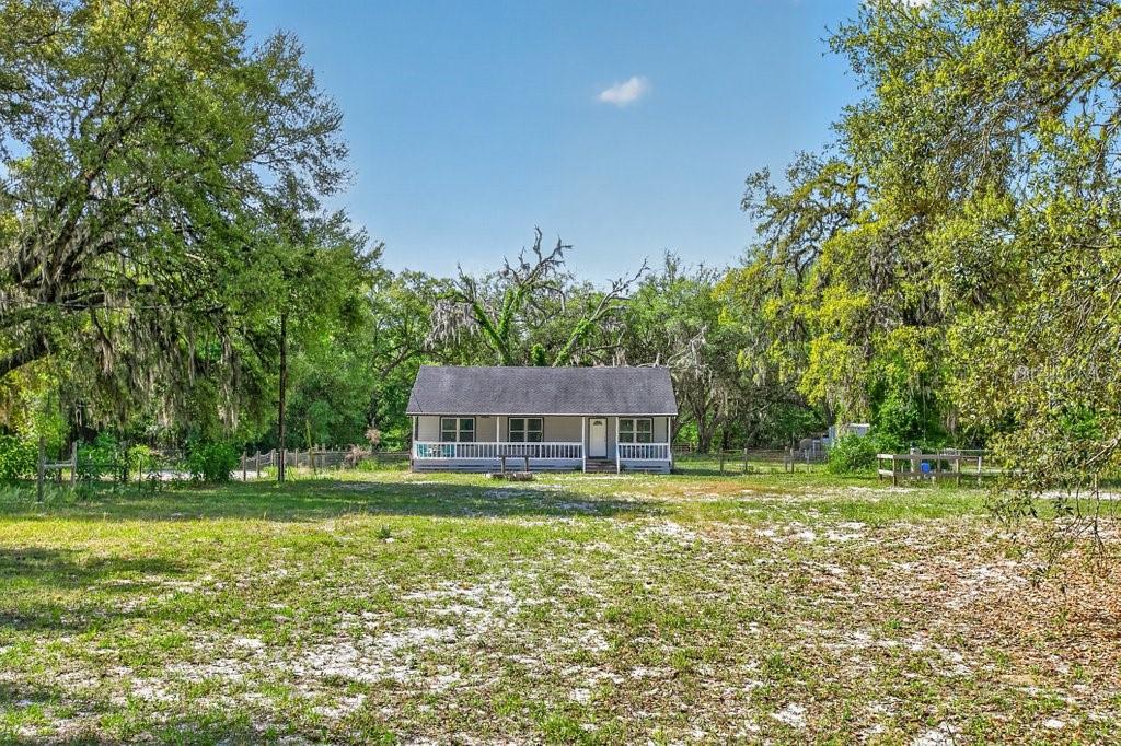 A single-story house with a front porch sits in a large, grassy, tree-lined lot — 461 OLD STARKE ROAD, PALATKA, FL
