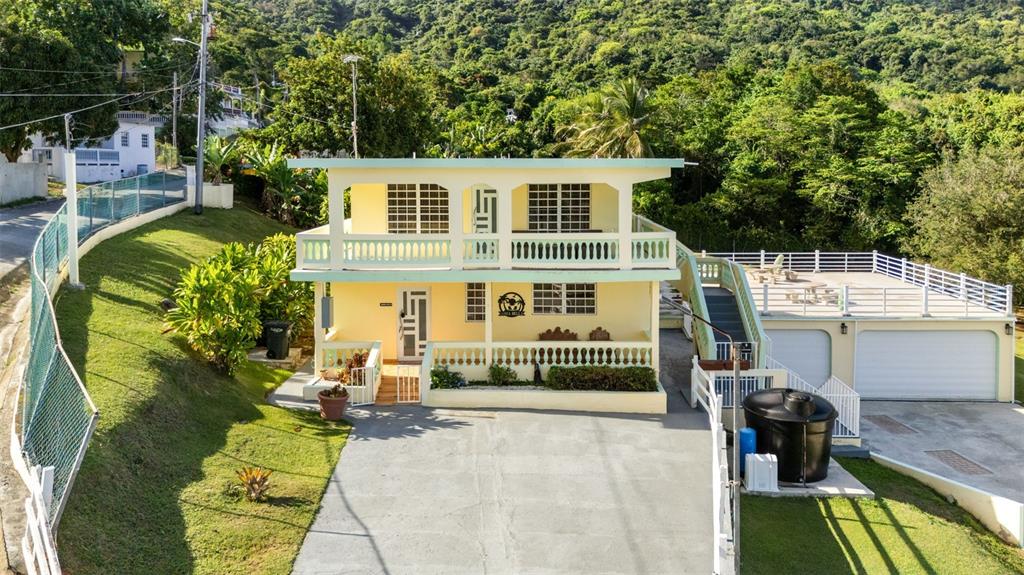 A two-story yellow house with a concrete driveway, a balcony, and a detached garage — Carr 3 CAMINO COOPERATIVO, PATILLAS, PR
