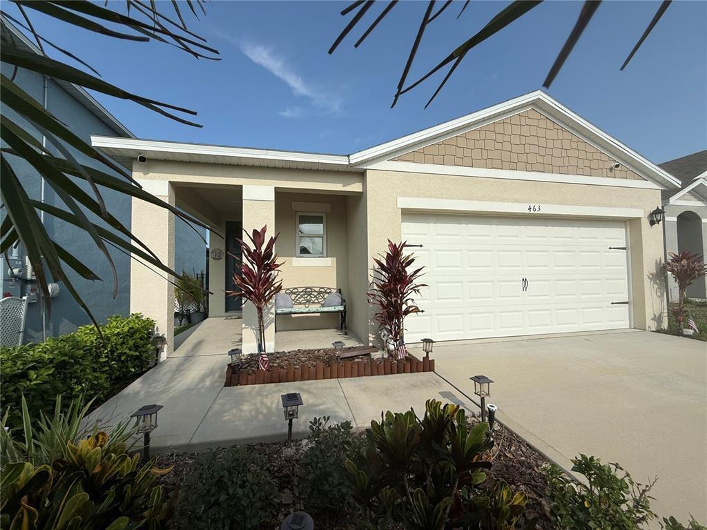 A single-story house with a beige stucco exterior, a two-car garage, and a front porch — 463 LIU LANE, DELAND, FL