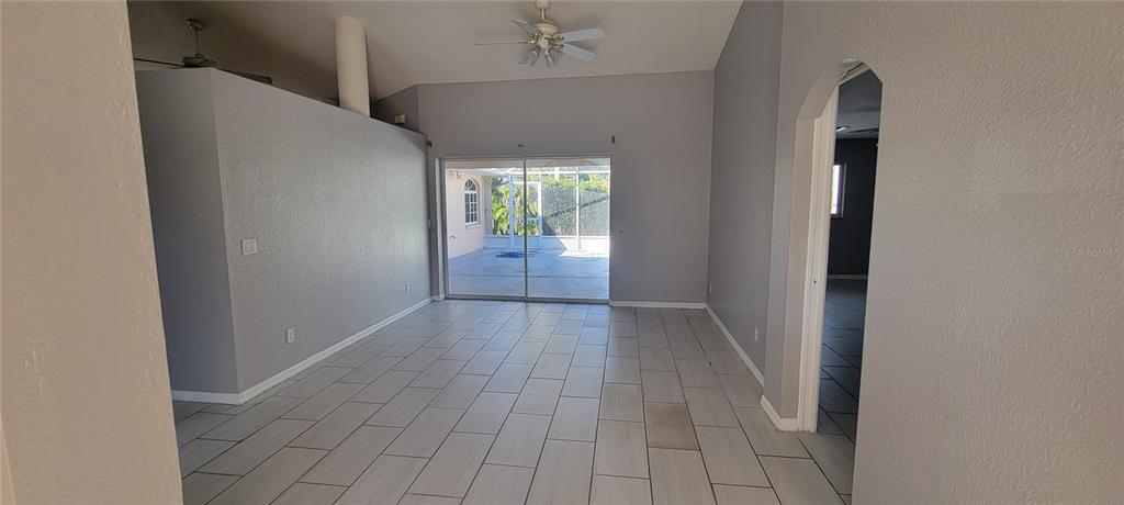 An interior view of a living room with gray walls, tile flooring, and sliding doors — 4147 BULA LANE, NORTH PORT, FL