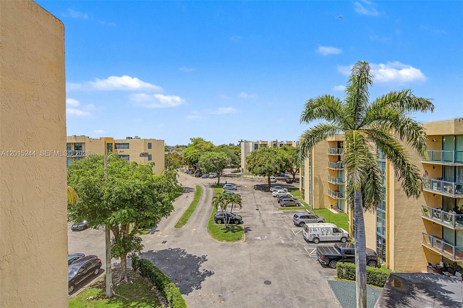 An elevated view shows a parking lot surrounded by apartment buildings and palm trees — 11790 SW 18th St # 3, Miami FL 33175, MIAMI, FL