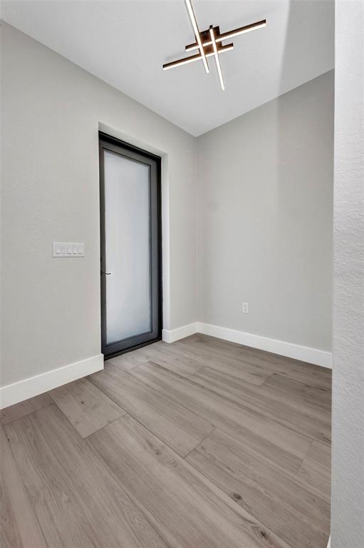 A small room with light gray walls, wood-look flooring, and a modern linear ceiling light — 1327 WESLEY DRIVE, PUNTA GORDA, FL