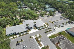 A rectangular outdoor swimming pool with a shallow entry step and surrounding patio seating — 4535 LONGWATER CHASE UNIT 18, SARASOTA, FL