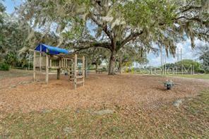 A concrete walkway leads to a fenced community swimming pool with a small building behind — 4535 LONGWATER CHASE UNIT 18, SARASOTA, FL