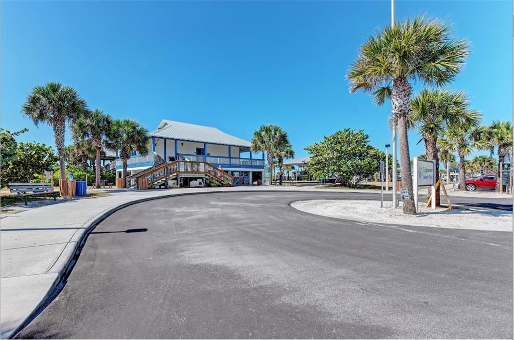 A paved driveway leads to a two-story building with a staircase at a beach park — 123 SUNSET ROAD, ROTONDA WEST, FL