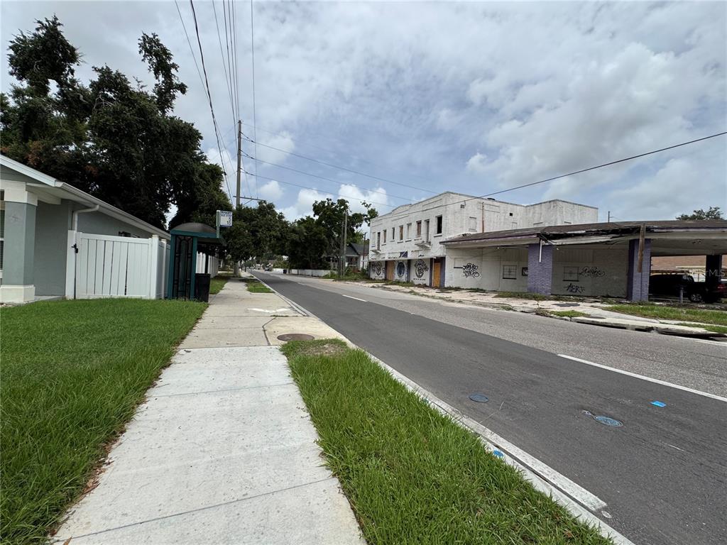 A street view shows a sidewalk, a bus stop, and a weathered commercial building — 2804 E COLUMBUS DRIVE, TAMPA, FL
