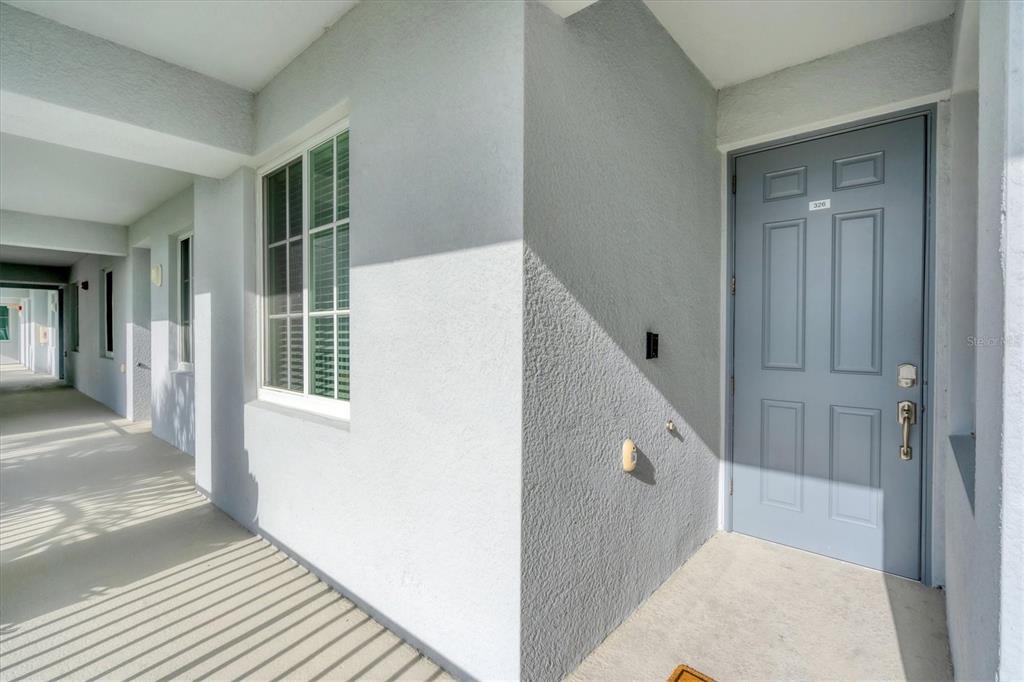 A light gray exterior door with the number 326 sits on a covered concrete walkway — 14071 HERITAGE LANDING BOULEVARD UNIT 326, PUNTA GORDA, FL