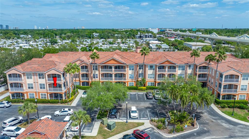An aerial view shows a multi-story apartment complex with a red-tiled roof and parking — 5000 CULBREATH KEY WAY UNIT 1-201, TAMPA, FL