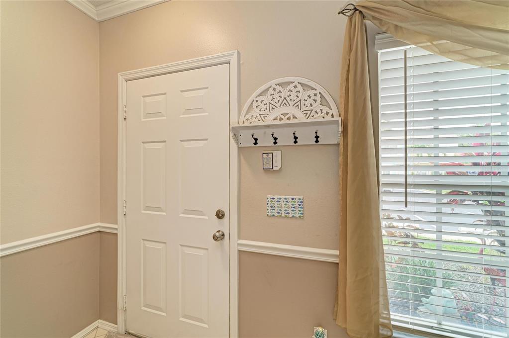 An entryway features a white door, a decorative wall shelf with hooks, and a window — 4634 SABAL KEY DRIVE, BRADENTON, FL