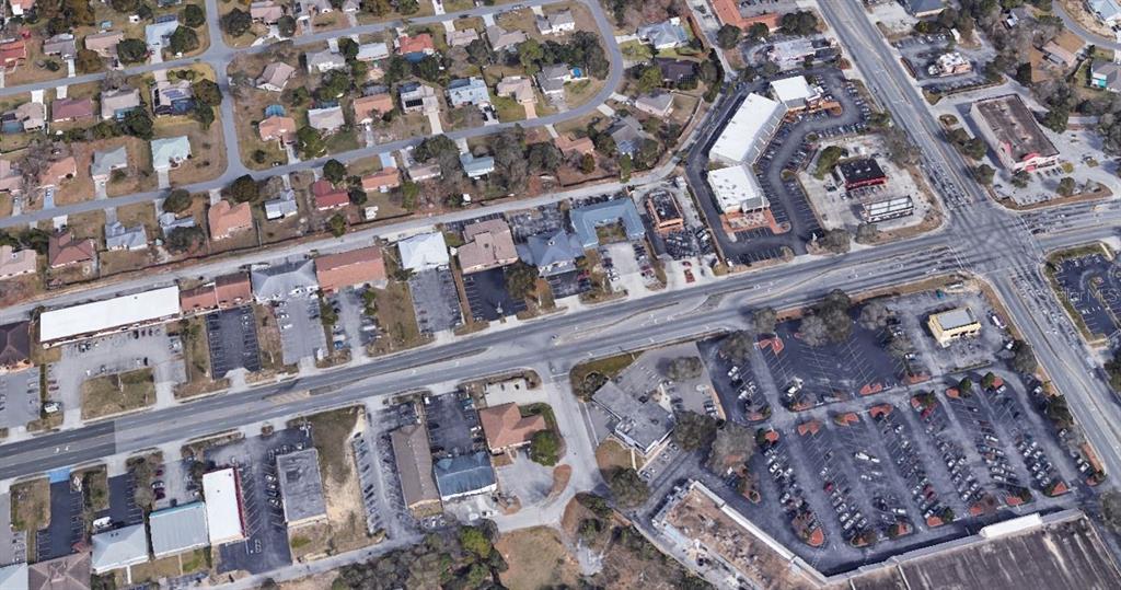 This aerial view shows a commercial area with buildings, parking lots, and intersecting roads — 11001 SPRING HILL DRIVE, SPRING HILL, FL