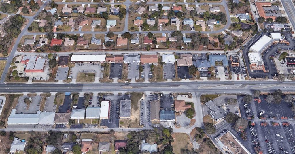 This aerial view shows a commercial strip center with parking lots along a multi-lane road — 11001 SPRING HILL DRIVE, SPRING HILL, FL