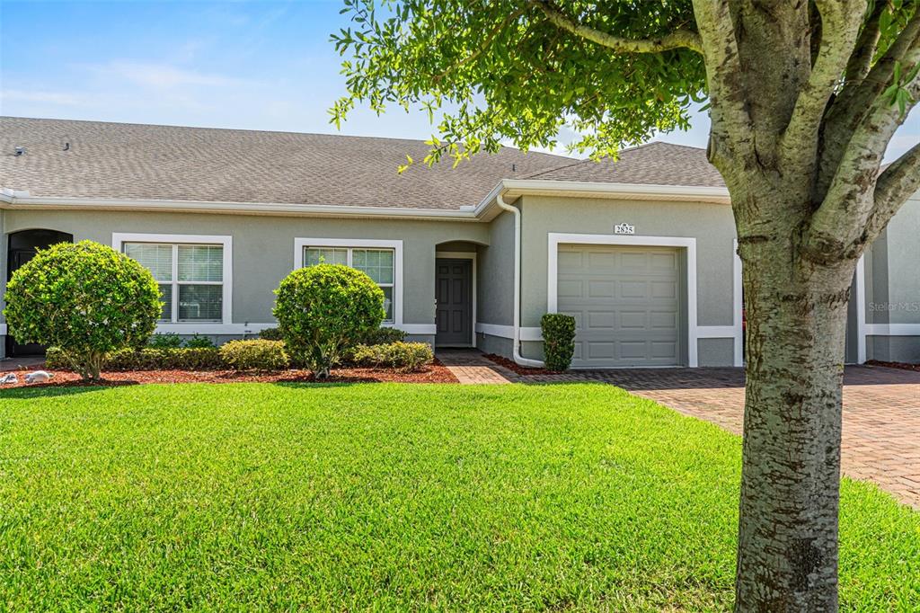 A single-story house exterior features a green lawn, a paved driveway, and a garage — 2825 ATTWATER LOOP, WINTER HAVEN, FL