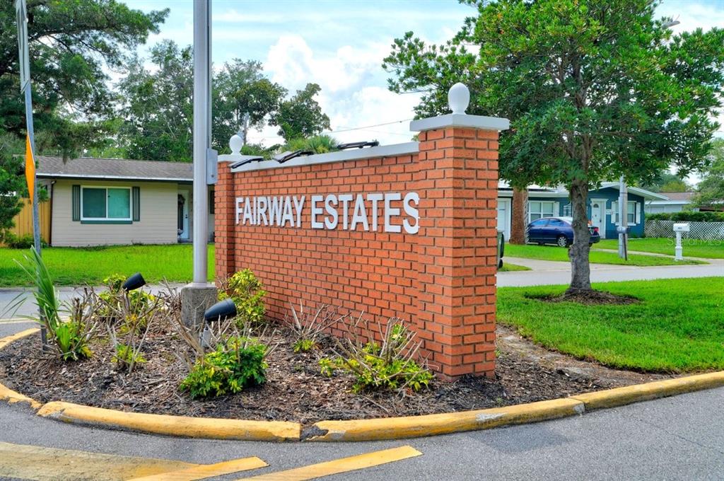 A brick entrance sign for Fairway Estates stands in a landscaped area near residential houses — 1309 SUWANEE ROAD, DAYTONA BEACH, FL
