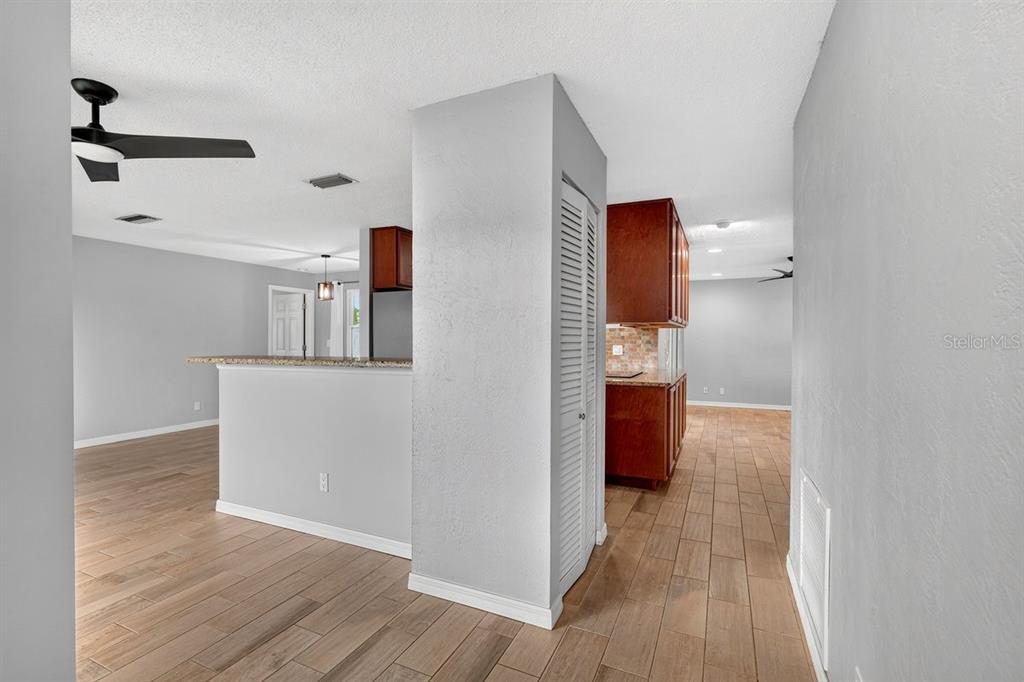 A view of an open-concept kitchen and living area with wood-look tile flooring — 1309 SUWANEE ROAD, DAYTONA BEACH, FL