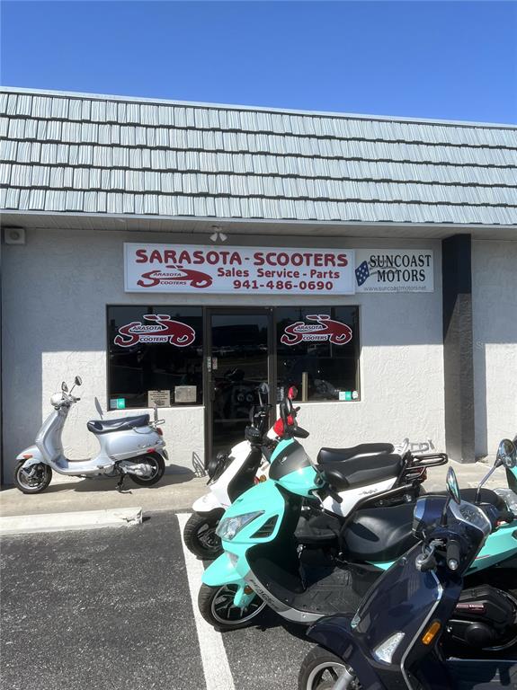 The exterior of a scooter shop features several parked scooters in front of the storefront — 853 US-41-BYP UNIT 853, VENICE, FL