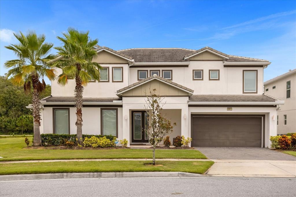 A two-story house with a white exterior, a two-car garage, and two palm trees — 3951 OAKVILLE AVENUE, KISSIMMEE, FL