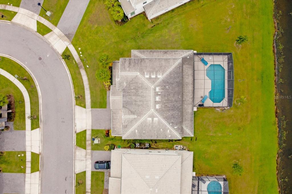 An aerial view shows a house with a pool enclosure, a driveway, and surrounding lawns — 3951 OAKVILLE AVENUE, KISSIMMEE, FL