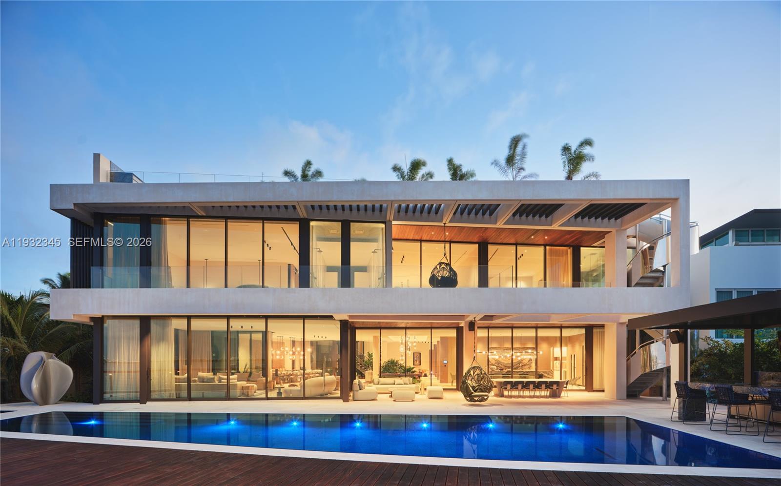 A modern two-story house with floor-to-ceiling glass walls overlooks a rectangular swimming pool — 1413 N Venetian Way, Miami FL 33139, MIAMI, FL