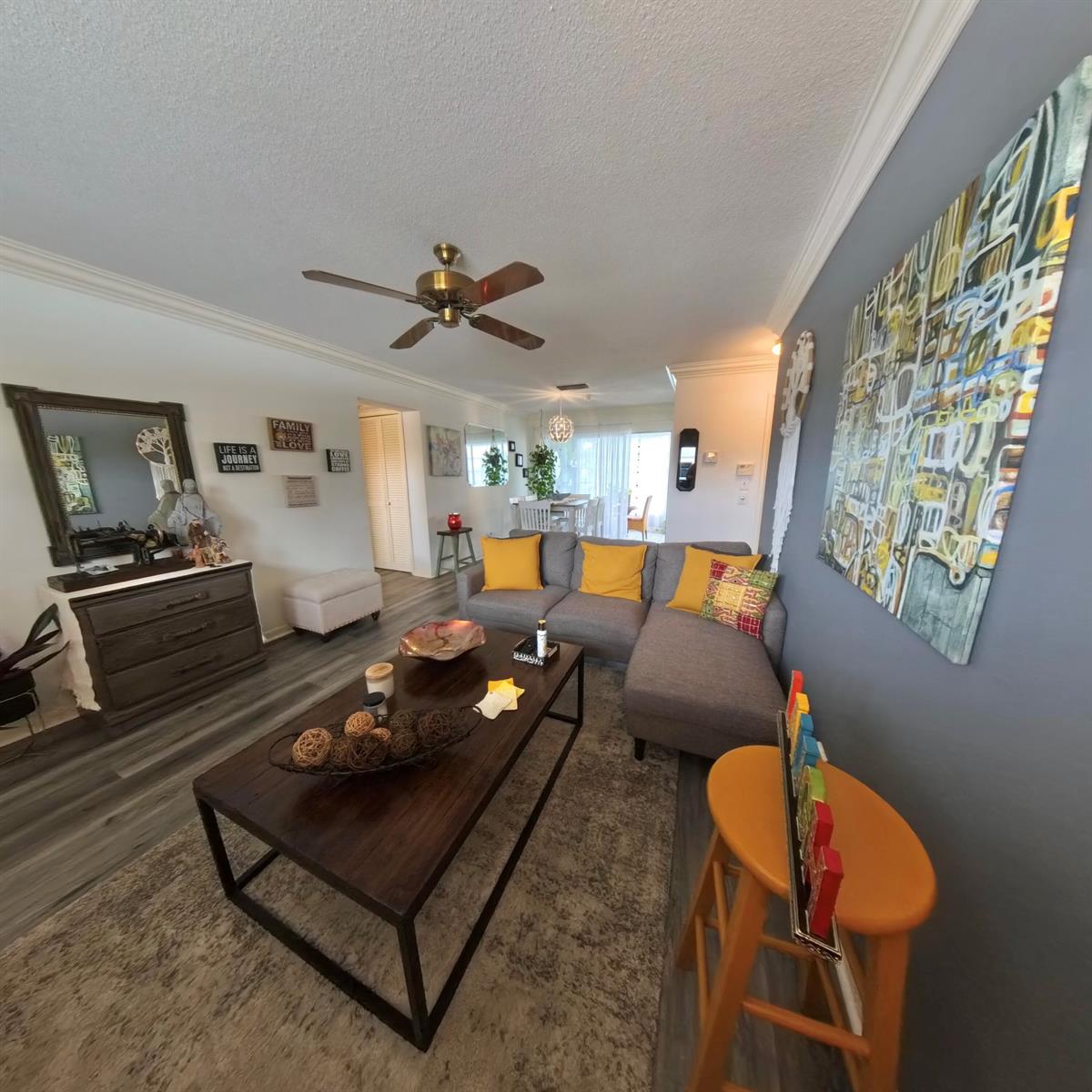 A living room features a gray sectional sofa, a dark wood coffee table, and gray flooring — 4100 Crystal Lake Drive # 209, Pompano Beach FL 33064, POMPANO BEACH, FL