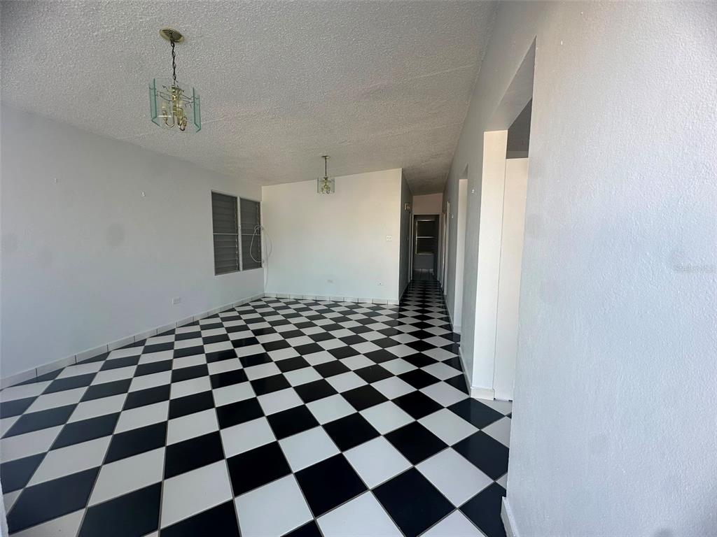 An empty room features a black and white checkered tile floor and two hanging lights — 7 JARDINES DE COUNTRY CLUB DEV. UNIT B-14, CAROLINA, PR