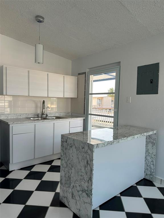 A kitchen features white cabinets, a marble-patterned island, and a black-and-white checkered floor — 7 JARDINES DE COUNTRY CLUB DEV. UNIT B-14, CAROLINA, PR