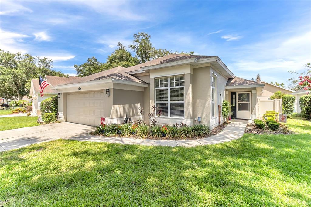 A single-story suburban house with a tan exterior, a two-car garage, and a front walkway — 661 ANDOVER CIRCLE, WINTER SPRINGS, FL