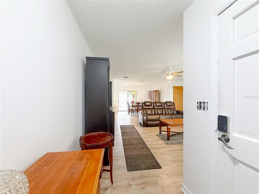An entryway opens into a living room and dining area with wood-look flooring — 1975 N SCENIC WAY, CRYSTAL RIVER, FL