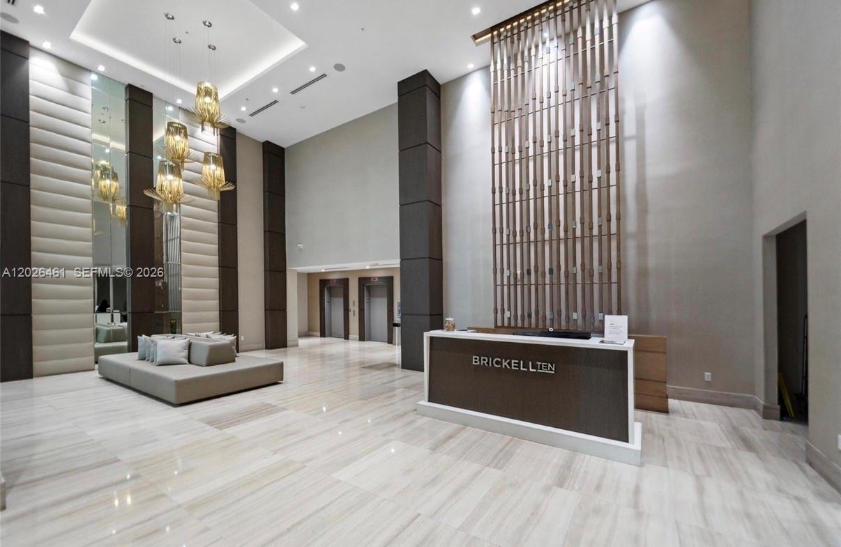 A modern building lobby features a reception desk, high ceilings, and a large seating area — 1010 SW 2nd Ave # 809, Miami FL 33130, MIAMI, FL