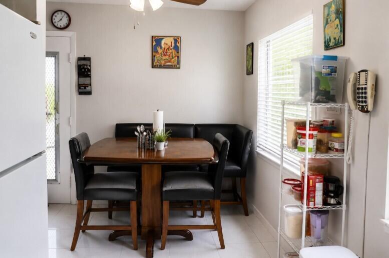 A dining area features a wooden table with black chairs and a corner bench — 321 Burgundy G, Delray Beach FL 33484, DELRAY BEACH, FL