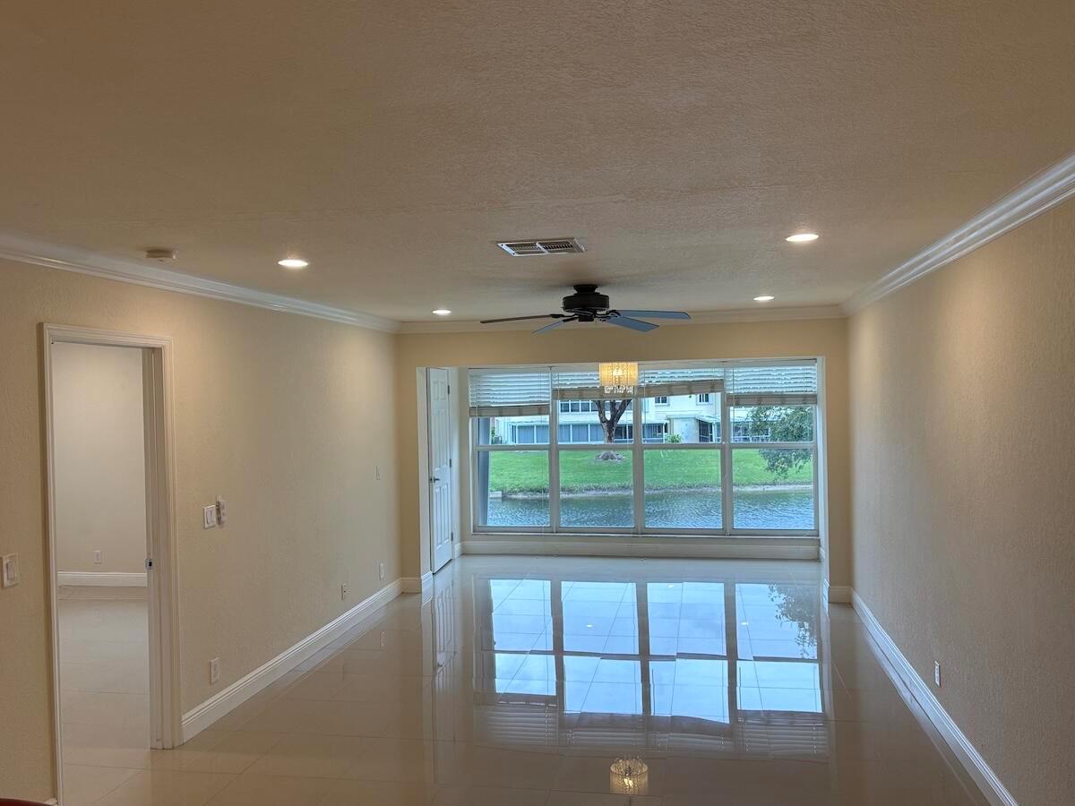 An empty room with light-colored tile floors, a ceiling fan, and a large window view — 1441 NW 19th Terrace # 201, Delray Beach FL 33445, DELRAY BEACH, FL