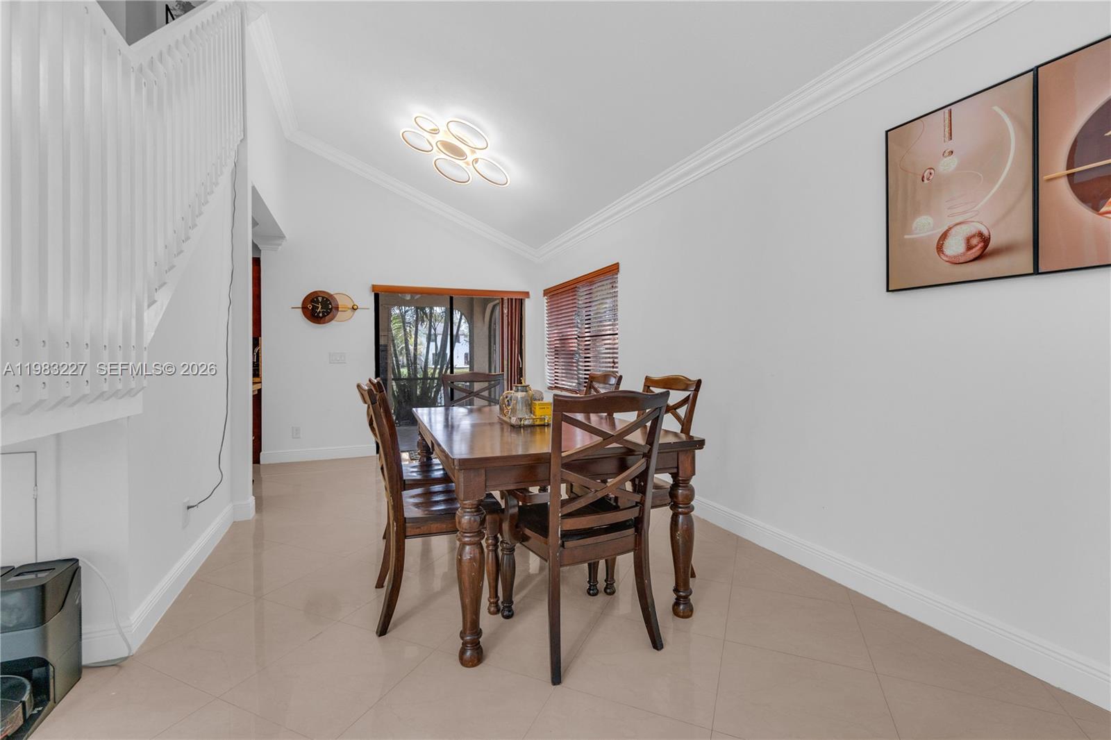 A dining room features a wooden table, chairs, tile flooring, and a vaulted ceiling — 2905 Begonia Way, Cooper City FL 33026, COOPER CITY, FL
