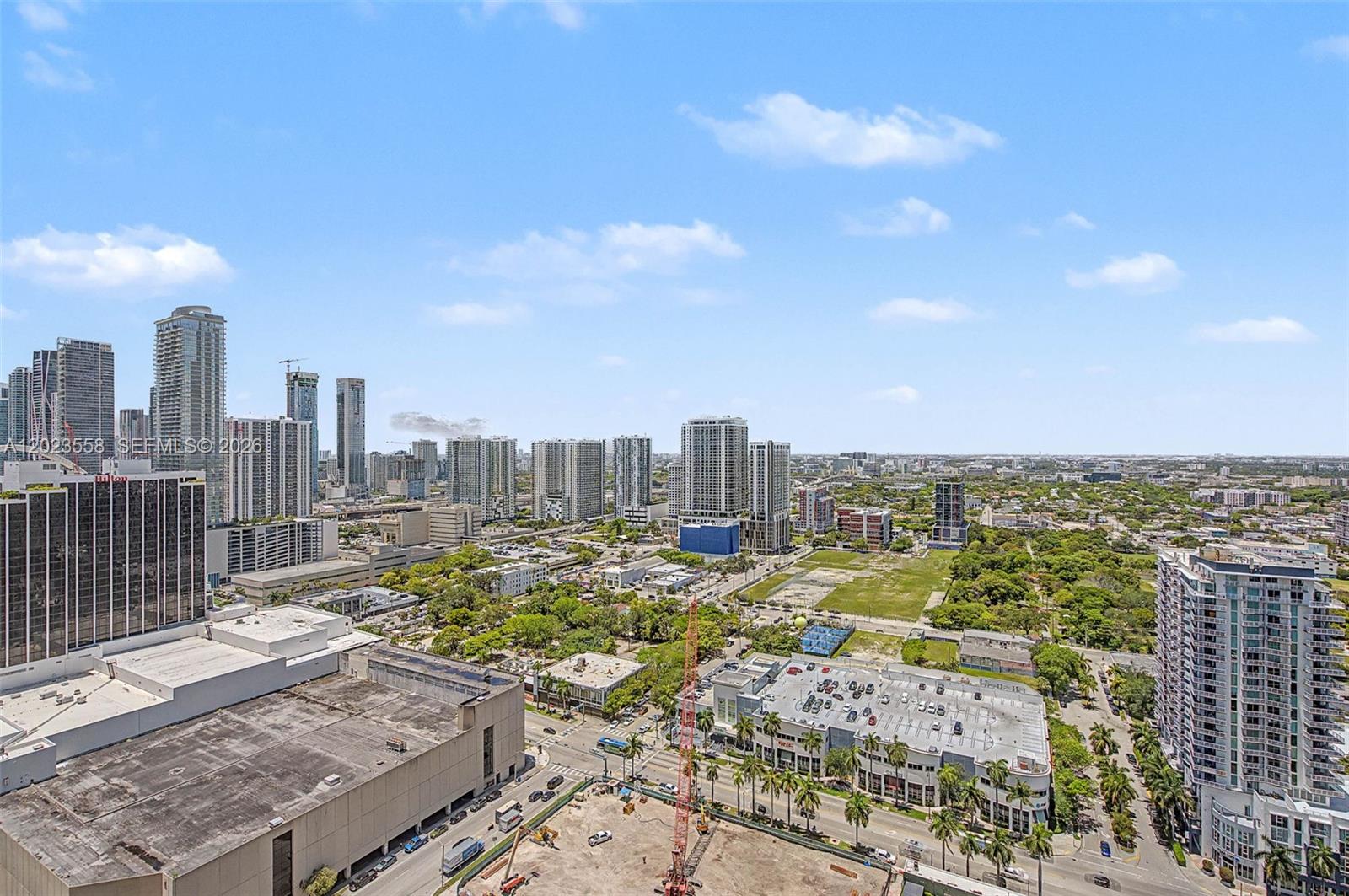 An elevated view shows a city skyline with tall buildings, green spaces, and street traffic — 488 NE 18th St # 3101, Miami FL 33132, MIAMI, FL