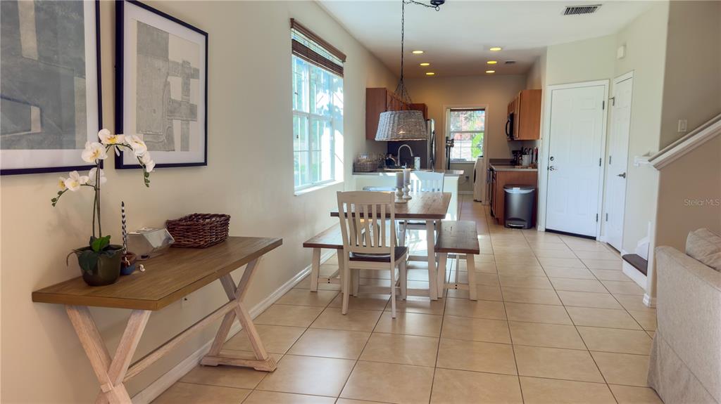 A dining area with a wooden table, benches, and a console table on tiled floors — 3756 82ND AVENUE CIRCLE E UNIT 101, SARASOTA, FL