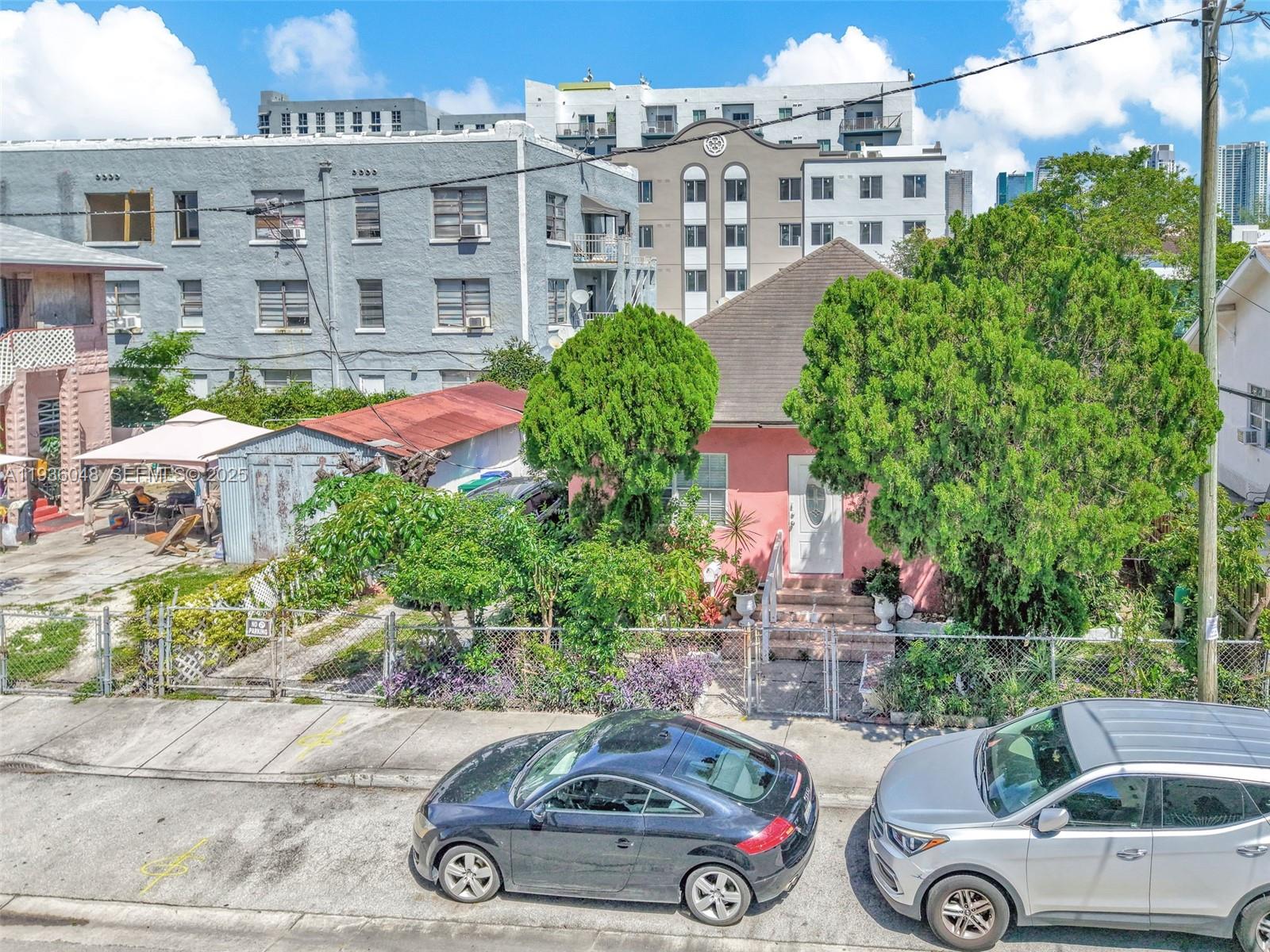 An aerial view shows a pink house with a metal-roofed shed and two parked cars — 119 SW 7th Ave, Miami FL 33130, MIAMI, FL