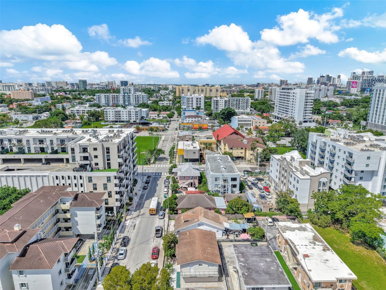 An aerial view shows a city street with residential buildings, parked cars, and a bus — 119 SW 7th Ave, Miami FL 33130, MIAMI, FL