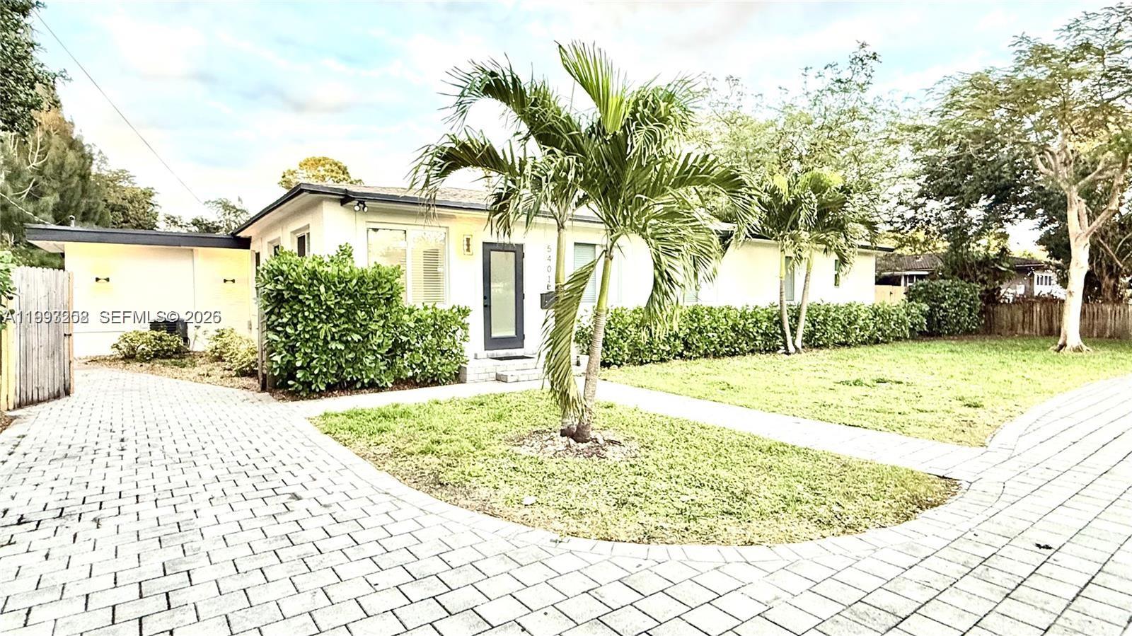 A single-story house with a paved driveway, a front lawn, and palm trees — 5401 W Broward Blvd, Plantation FL 33317, PLANTATION, FL