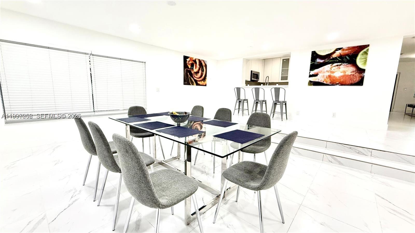 A dining room features a glass table, gray chairs, and white marble-style flooring — 5401 W Broward Blvd, Plantation FL 33317, PLANTATION, FL