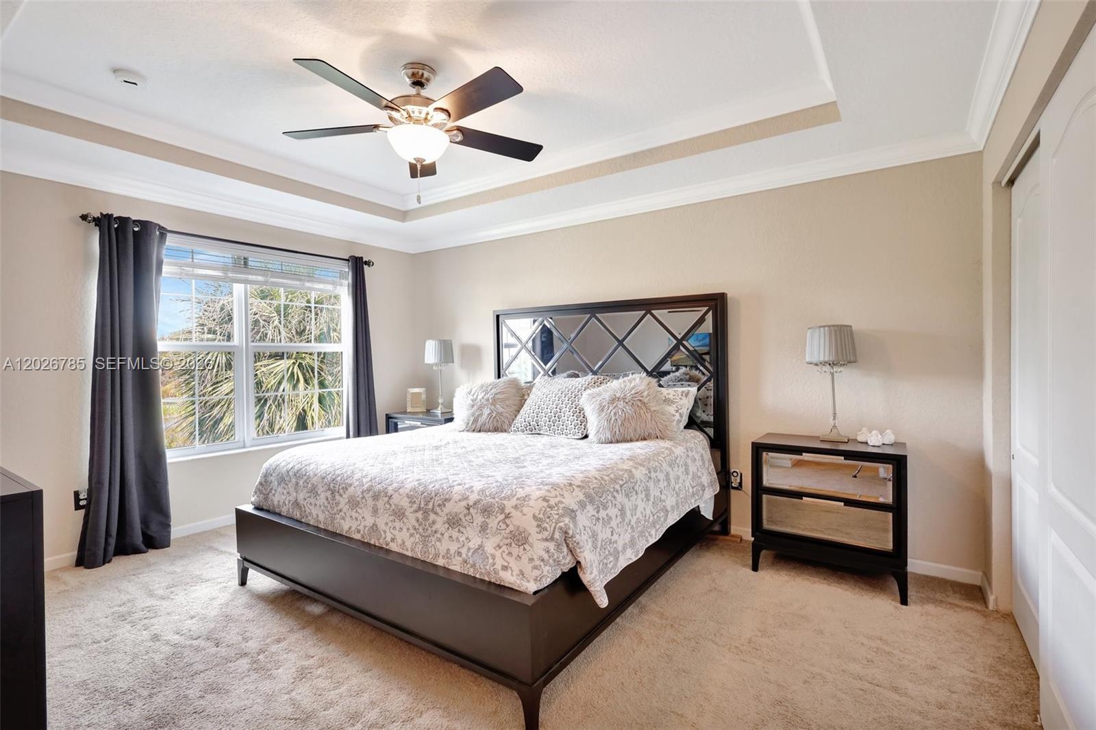 A bedroom features a bed with a mirrored headboard, two nightstands, and a ceiling fan — 4302 Colony View Dr, Lake Worth FL 33463, LAKE WORTH, FL