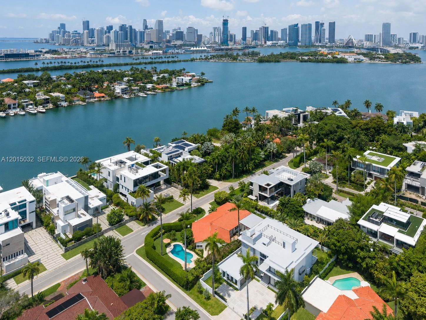 An aerial view shows luxury waterfront homes with pools and palm trees near a city skyline — 363 S Hibiscus Dr, Miami Beach FL 33139, MIAMI BEACH, FL